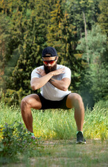 Bearded athletic man doing workout exercise in the outdoor gym in sunset
