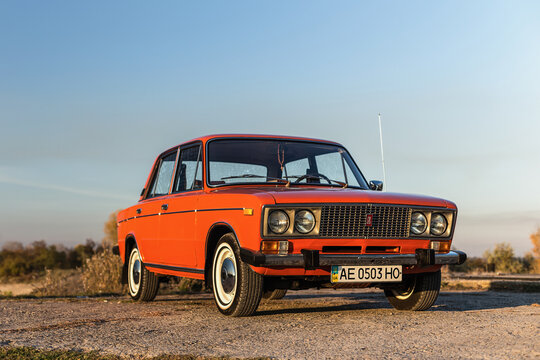 Pereshchepino, Ukraine - October 12, 2014: Zhiguli vaz 2106 original orange, released in the ussr in 70's. car parked near the river, autuman time