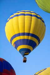 Fototapeta premium Yellow and blue hot air balloon in the blue sky