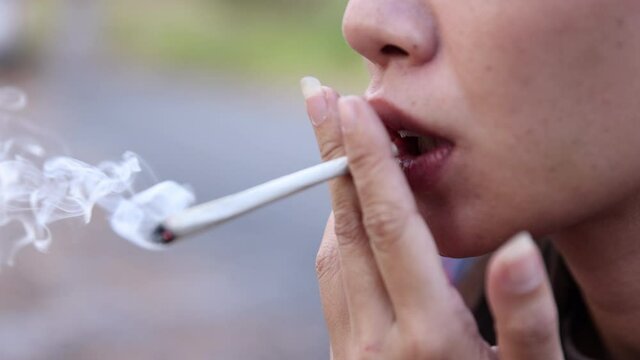 Slow motion of woman smoking weed cannabis joint