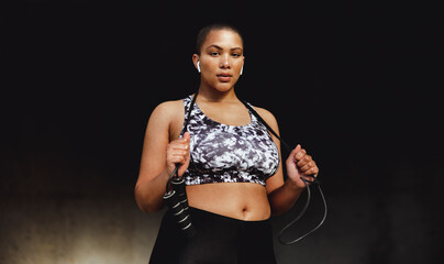 Obraz premium Fitness woman relaxing outdoors holding a skipping rope