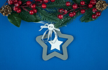 winter christmas background with fir branches cones and berries on blue background. Holidays Christmas background. Space for text or design.