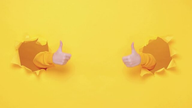 Woman hands pointing finger camera showing thumbs up like say you cool isolated through torn yellow background studio. Copy space advertisement place for text image Advertising area workspace mock up