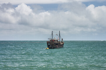 pirate boat on the high seas with clouds in the background
