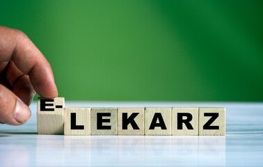 hand turns the wooden cube and changes the polish word LEKARZ (english doctor) with green positive...