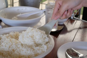 cooked rice in ladle hand held scoop from pot