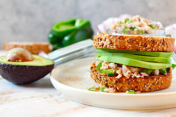 Sandwich with tuna, avocado and vegetables for snack or lunch. Top view with copy space.