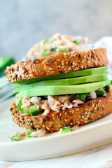 Sandwich with tuna, avocado and vegetables for snack or lunch. Top view with copy space.