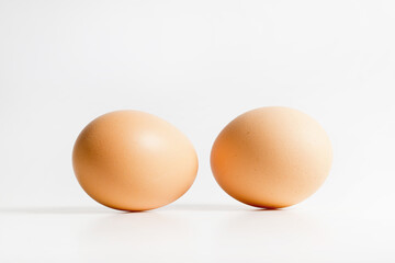 Two brown organic fresh raw eggs. Cut out and isolated on white background with soft shadows for added dimension.