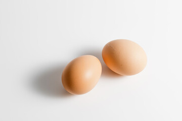 Two brown organic fresh raw eggs. Cut out and isolated on white background with soft shadows for...