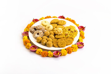 diwali snacks kept on Rangoli design made with flower petals of rose and marigold  for Diwali celebration in India