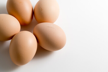 Five brown organic fresh raw eggs. Cut out and isolated on white background with soft shadows for added dimension.