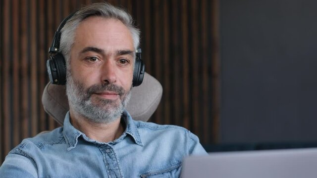 CloseUp of Concentrated freelance Businessman using laptop Device at Home office, working Distantly. Focused Man working on Laptop. Concept of Distantly Work, Freelance, Businessman, Digital nomad.