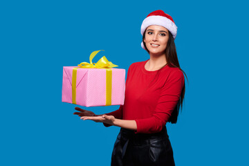 Fototapeta na wymiar Smiling woman in Santa's hat with gift box over blue isolate background