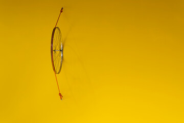 vintage bicycle wheel/tire on a yellow wall