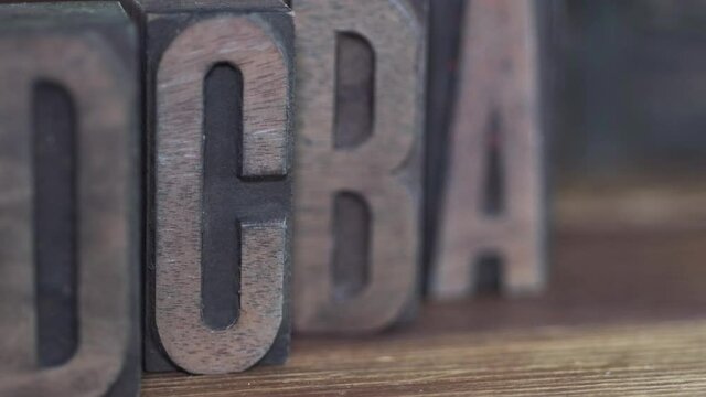 closeup wooden alphabet background, diagonal right to left camera tracking 
