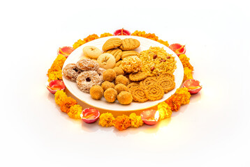 diwali snacks kept on Rangoli design made with flower petals of rose and marigold  for Diwali celebration in India