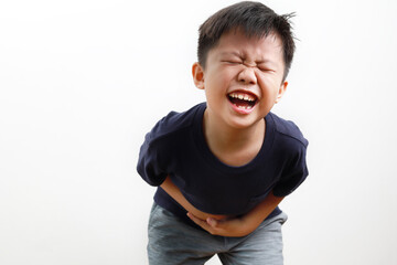 Sad little Asian boy suffering from stomach ache, holding his stomach, isolated on a white background.