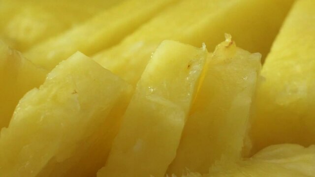 Close-up of freshly cut pineapple bits, panning