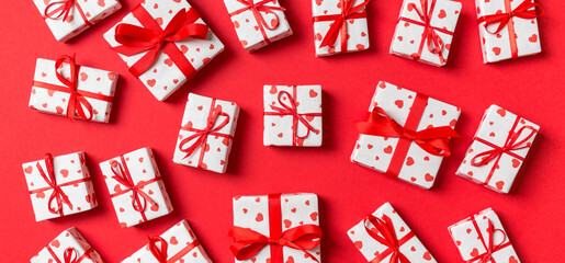 Fototapeta na wymiar Composition of holiday white gift boxes with red hearts on colorful background. Valentine's day concept