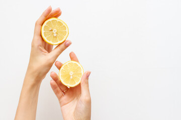 Woman holding half of fresh lemon, free space for text