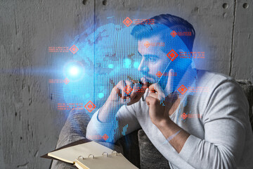 Handsome businessman in casual wears, speaking phone, taking notes at office try to solve global international issue. Double exposure. The concept of international business. Planet hologram.