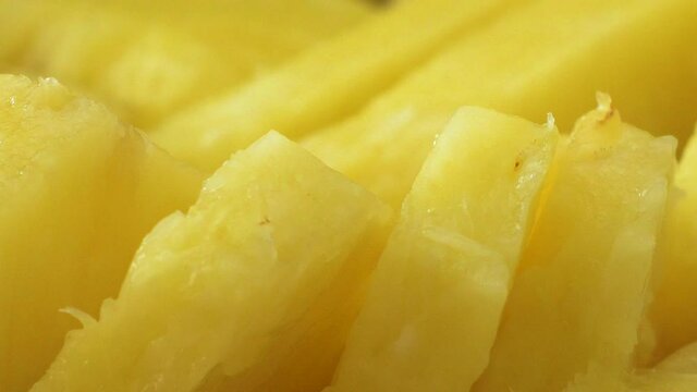 Close-up of freshly cut pineapple bits, tilt up