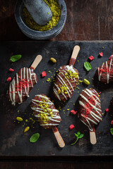 Tasty Popsicles with  pistachios and chocolate topping