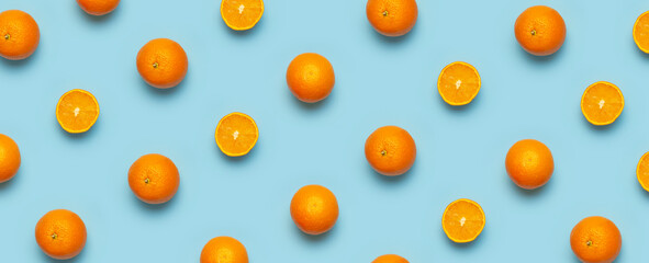 Fruit pattern, creative summer concept. Fresh juicy whole and sliced orange on blue background. Flat lay Top view. Minimalistic background with citrus fruits, vitamin C. Pop art design Banner