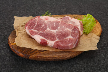 Raw pork steak over wooden board