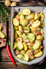 Top view of baked potatoes with cherry tomatoes and garlic