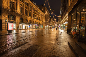 Naklejka na ściany i meble Helsinki, Finland November 30, 2020 Old town streets in the evening, decorated for Christmas, after the rain. Burning lights and reflections.
