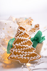Homemade gingerbread in the shape of a Christmas tree decorated with white glaze. Christmas treats.