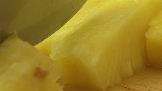 Close-up of knife cutting through fresh pineapple