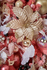 beautiful golden christmas flower on pink christmas tree together with other christmas tree decorations