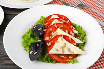 Salad with fresh tomatoes and brined cheese, sunflower seeds on top