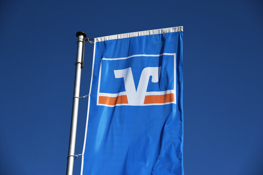 Bispingen, Lower Saxony, Germany - April 19, 2020: Flag with the logo of the german credit union Volksbank - Raiffeisenbank, Germany