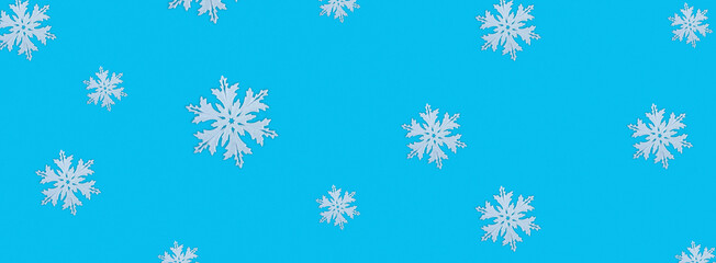 Christmas pattern of white snowflakes on a blue background. Concept banner frame border background for Christmas and New Year.