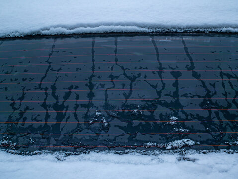 Melting snow on the car window glass. Car window glass. Snow melting. Water drops. Winter period. Frosty frost. Frozen water. Vehicle. Caring for a vehicle in winter. Background image.