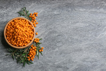 Fresh ripe sea buckthorn on grey table, flat lay. Space for text
