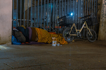 Homeless Man sleeping on sidewalk, Homeless man sleeping in winter, homeless man in sleeping bag on...