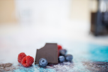 Bitten chocolate bar and berries on a colorful placemat