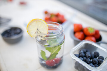 Lemon slice on the edge of a glass with berries inside