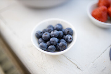 Blueberries on a small plate on a white table