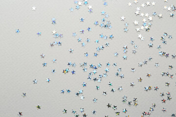 Confetti stars on grey background, flat lay Christmas celebration