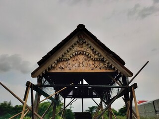 Asian wooden house roof against a cloudy sky background