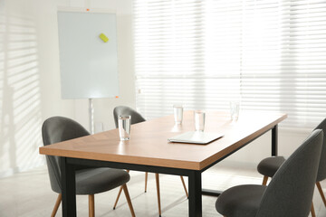 Conference room interior with wooden table and flipchart