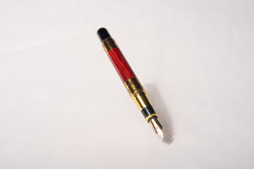 Antique fountain pen, fountain pen released in the air with drop shadow on light gray background, selective focus.