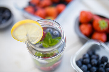 Lemon slice on the edge of a glass with berries inside