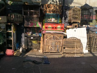 The shop sells bird cages that are on the side of the road